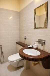 a bathroom with a sink and a toilet and a mirror at Hotel Sunshine Inn in Mughal Sarāi +5 photos