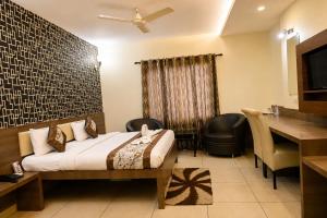 a hotel room with a bed and a desk at Hotel Sunshine Inn in Mughal Sarāi