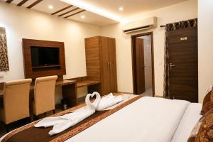 a hotel room with a bed with towels on it at Hotel Sunshine Inn in Mughal Sarāi