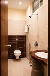a bathroom with a toilet and a sink at Hotel Sunshine Inn in Mughal Sarāi