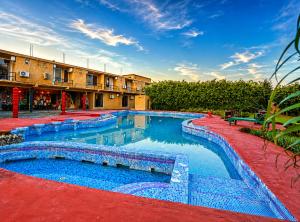 a swimming pool in a courtyard with a building at Corbett Soho Resort in Haldwāni