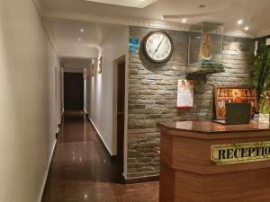 a clock on a brick wall in a hallway at Matha Residency Munnar in Suryanelli