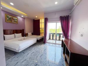 a hotel room with two beds and a large window at Cloudy Hill Homestay and Hostel in Kampot