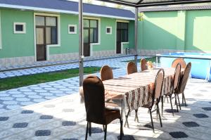 a table and chairs sitting next to a pool at Seki Qonaq Evi in Sheki