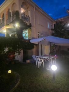 a table and umbrella in the yard of a house at night at Casa Angelina in Polychrono