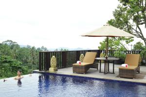 a woman is swimming in a swimming pool at Puri Karang Besakih in Menanga