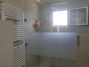 a bathroom with a shower with a sink and a window at Appart Cosy in Fnidek +12 photos