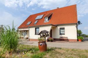 a white house with an orange roof with windows at Andrea Vacation Home in Döbeln