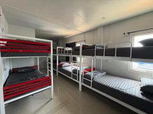 a room with three bunk beds and a window at Like A Friend Hostel in Thong Sala