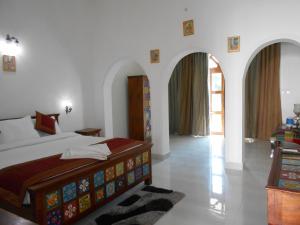 a bedroom with a bed and a room with arches at Hotel isabel Palace in Khajurāho