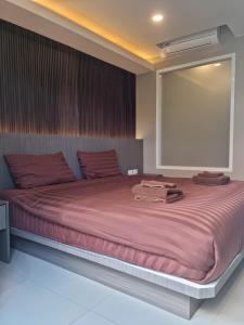 a bedroom with a large bed with red sheets at Sitara Patong Beach in Patong Beach