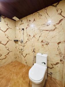 a bathroom with a toilet and a marble wall at Odyssey Rendezvous in Chottanikara +15 photos