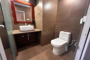 a bathroom with a toilet and a sink and a mirror at FabHotel Maitree Beach Resort in Arambol