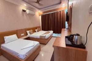 a hotel room with two beds and a television at FabHotel Maitree Beach Resort in Arambol +16 photos
