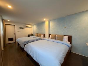 two beds in a room with blue walls at Frania Sea Suites in san juan la union