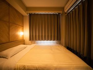 ein Schlafzimmer mit einem großen Bett und einem Fenster in der Unterkunft Super Hotel Kobe in Kōbe