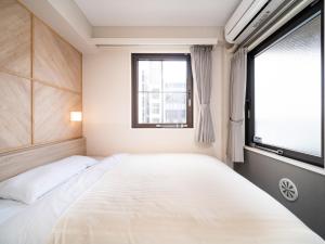 ein Schlafzimmer mit einem großen Bett und einem Fenster in der Unterkunft Super Hotel Kobe in Kōbe