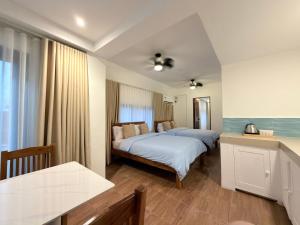 a hotel room with two beds and a table at Frania Sea Suites in san juan la union