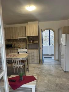 a kitchen with a table and a white refrigerator at Panorama Hotel in Kalymnos