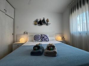 a bedroom with a bed with towels on it at Repòs Mar i Muntanya in Perelló
