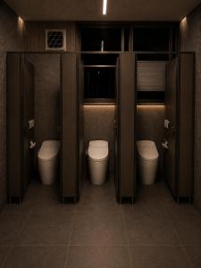 a bathroom with three toilets and two stalls at LUX Niseko lodge in Niseko