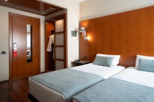 a hotel room with two beds and a door at Hotel Ciutat Martorell in Martorell +22 photos
