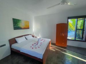 a bedroom with a bed with flowers on it at Whisky Point Surf Cabanas in Ampara +59 photos