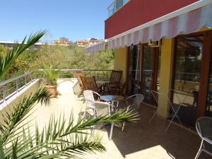 a patio with chairs and tables on a balcony at Hotel Buena Vissta in Primorsko