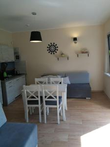 a kitchen and dining room with a table and chairs at Domki Pod Szyszką 500m od morza in Rowy