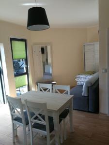 a living room with a table and a couch at Domki Pod Szyszką 500m od morza in Rowy