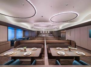 a dining room with tables and chairs and lights at Orange Crystal Hotel Ningbo Ninghai in Ninghai