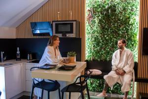 Ein Mann und eine Frau sitzen an einem Tisch in der Küche. in der Unterkunft Suites Wellness à Sprimont - Logements avec jacuzzi pour 2 personnes in Sprimont