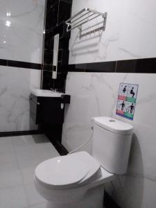 a bathroom with a white toilet and a sink at BIN DAOD Hotel Syariah in Meulaboh +10 photos
