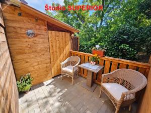 a patio with chairs and a table and a shed at MK Apartment Karpaty in Zvončín