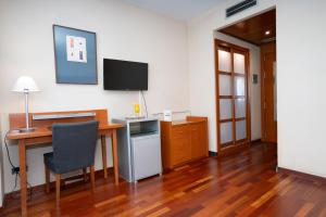 a room with a desk and a television on a wall at Hotel Ciutat Martorell in Martorell