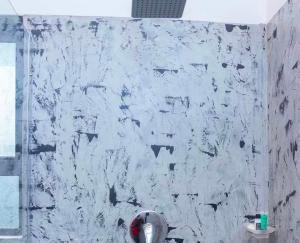 eine weiße Marmorwand in einem Badezimmer mit Toilette in der Unterkunft Narvira in Kona