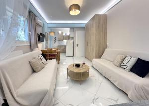 a living room with two couches and a table at SEMIRAMIS SUITES with pool in Kalamata