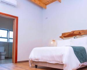 ein Schlafzimmer mit einem weißen Bett mit hölzernem Kopfteil in der Unterkunft Narvira in Kona