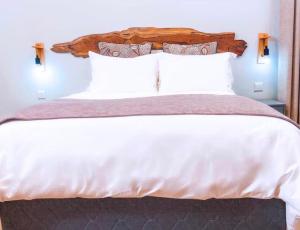 ein Schlafzimmer mit einem großen weißen Bett und weißen Kissen in der Unterkunft Narvira in Kona