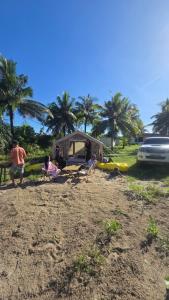 a group of people on a beach with a tent and palm trees at Luxary Tent in Kudat