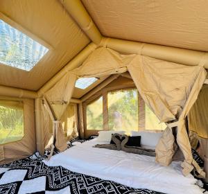 a bed in a tent with two windows at Luxary Tent in Kudat