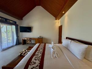 a bedroom with a large bed in a room at Atta Residence by Manara in Seraya