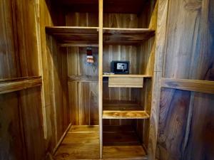 a wooden walk in closet with wooden walls and wooden floors at Atta Residence by Manara in Seraya