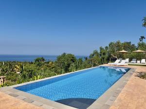 a swimming pool with a view of the ocean at Atta Residence by Manara in Seraya