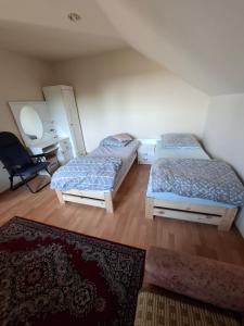 a bedroom with two beds and a desk and a chair at Pokoje u Zbigniewa in Chechło +3 photos