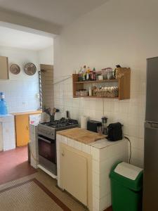 a kitchen with a stove and a green trash can at Malika Surf House in Dakar +3 photos