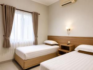 a bedroom with two beds and a window at Wisma Pelangi 5 in Jakarta +5 photos