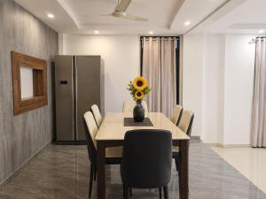 a dining room with a table with a vase of flowers on it at Gods Gift in Murbād
