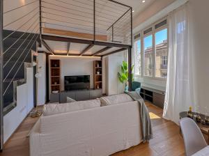 a living room with a white couch and a large window at FLATSHARING - SPADARI Duomo Suites in Milan