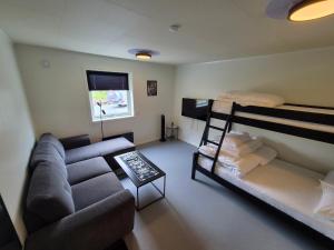 a living room with a couch and a bunk bed at Camp Mefjord in Senja